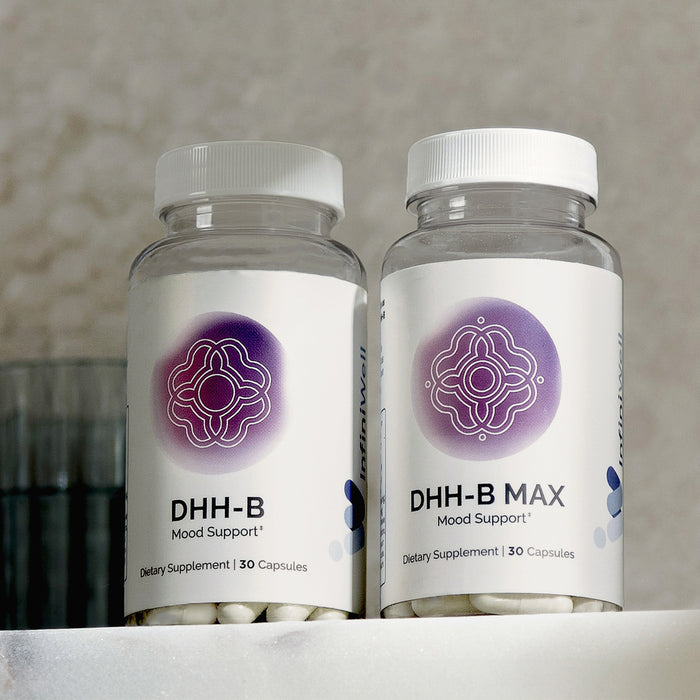 Infiniwell DHH-B Mood Support and DHH-B MAX Mood Support supplement bottles with 30 capsules on light surface