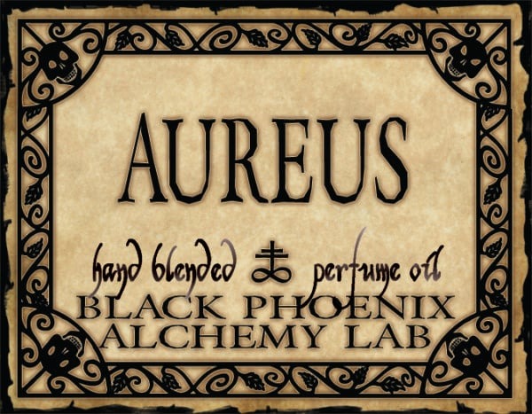 Label for Aureus hand blended perfume oil by Black Phoenix Alchemy Lab with decorative border.