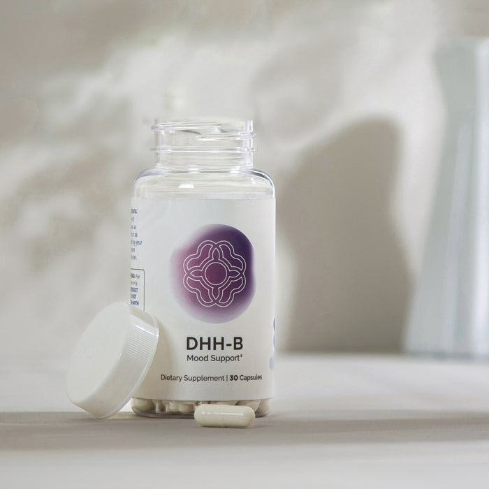 InfiniWell DHH-B Mood Support dietary supplement bottle with open lid and capsules on a neutral surface, 30 capsules.