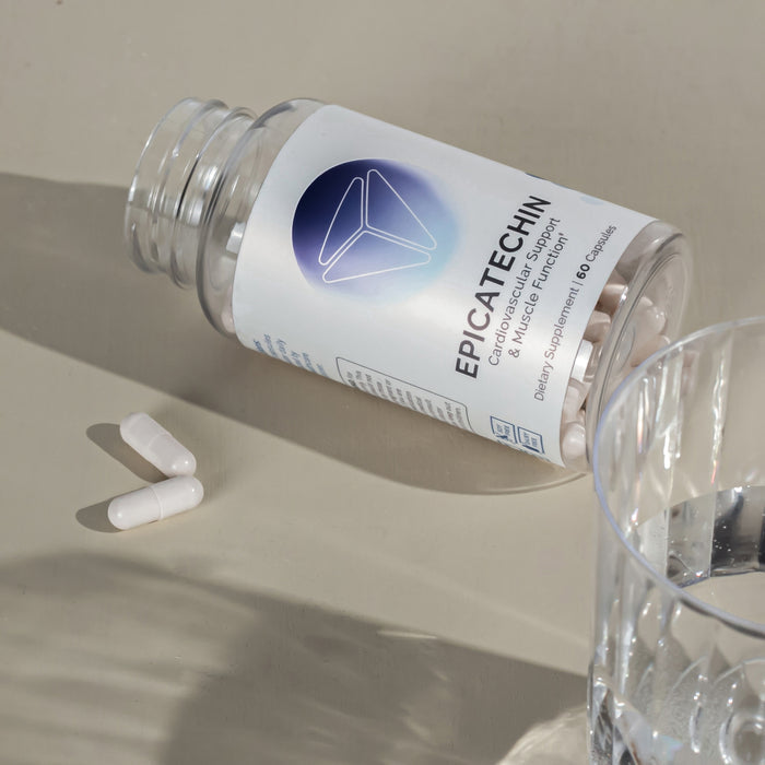 Infiniwell Epicatechin bottle on side with loose capsules and glass of water, cardiovascular and muscle function
