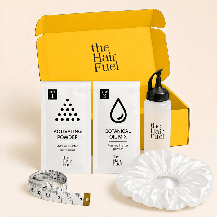 The Hair Fuel hair care starter kit displayed on a light beige background, featuring a bright yellow box, white packets of activating powder and botanical oil powder, a white oil bottle with a black pump, a silver measuring tape, and a white satin scrunchie.