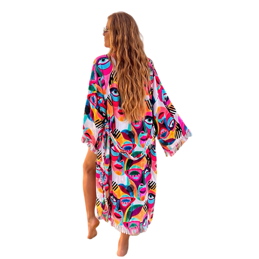 Woman wearing colorful Karli Buxton Picasso print organic cotton kaftan on the beach