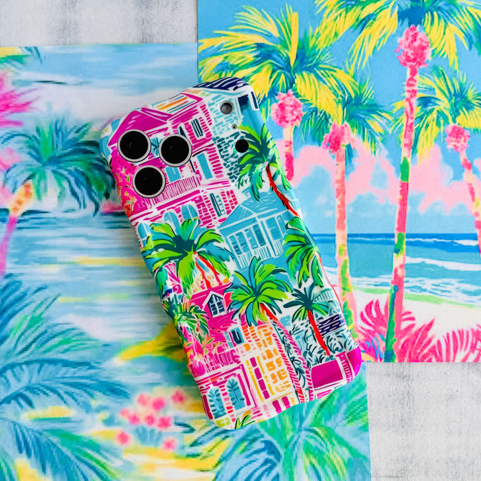 Trendy wavy iPhone case featuring a vibrant tropical resort scene with pink villas and green palm trees with a high-gloss finish.