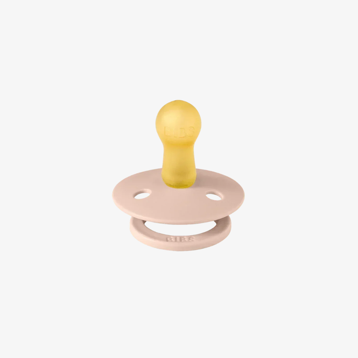 Natural rubber and pink pacifier on a white background