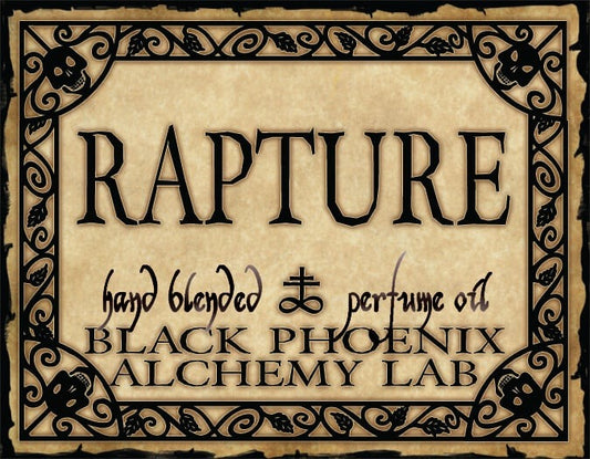 Advertisement for 'Rapture' hand blended perfume oil by Black Phoenix Alchemy Lab with decorative border and text.