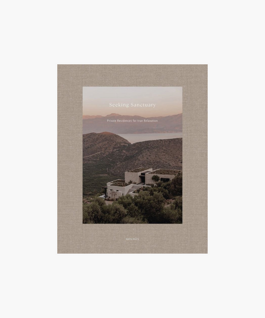 A minimalist building sits amidst lush greenery on a hill overlooking a calm sea, with the tranquil caption, "Seeking Sanctuary: Private Residences for True Relaxation." | Wildwood Home Co.
